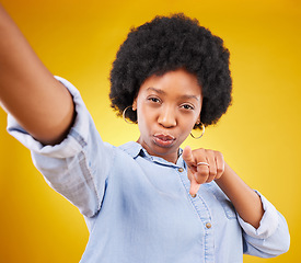 Image showing Portrait, selfie and black woman pointing to you in studio isolated on a yellow background. Face, emoji and serious female model taking photo for profile picture or social media with hand gesture.