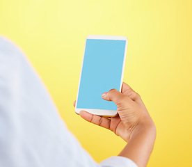 Image showing Phone mockup, hands and green screen in studio isolated on a yellow background. Cellphone, social media and black woman typing on smartphone for advertising space, marketing or product placement.