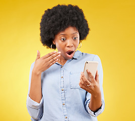 Image showing Phone, surprise and shock of black woman in studio isolated on a yellow background. Wow, cellphone and surprised African female with smartphone for reading fake news on social media, omg or wtf emoji