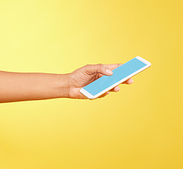 Image showing Hands, phone mockup and green screen in studio isolated on a yellow background. Cellphone, social media and black woman holding mobile smartphone for advertising space, marketing or product placement