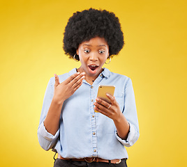 Image showing Phone, surprise and wow of black woman in studio isolated on a yellow background. Shock, cellphone and surprised female with smartphone for good news on social media, winning lottery or competition.