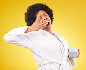 Image showing Yawning, coffee and tired black woman in studio, waking up and sleepy on yellow background space. Exhausted, yawn and female with tea in bathrobe, emoji and fatigue gesture while posing isolated