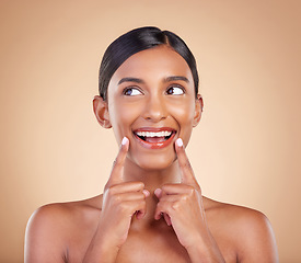 Image showing Indian woman, skincare and hands for thinking in studio with face, smile and wellness by background. Young asian model, girl and cosmetics for natural skin glow, aesthetic or happiness for idea