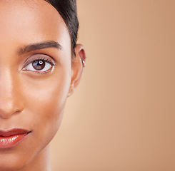 Image showing Portrait, beauty and mockup with a model woman in studio on a beige background to promote skincare. Face, eye and mock up with an attractive young female posing for cosmetics or luxury wellness