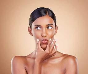 Image showing Pout, beauty and Indian woman with skincare, makeup and cosmetic glow and clear skin isolated in a studio brown background. Thinking, self care and face of natural female model with facial routine