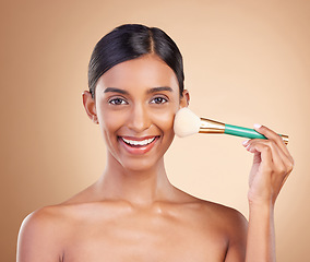 Image showing Portrait, beauty and blush with a model woman in studio on a beige background to promote makeup. Face, brush and cheek with an attractive young female posing for cosmetics or luxury wellness