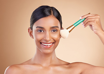 Image showing Portrait, beauty and blusher with a model woman in studio on a beige background to promote makeup. Face, brush and cheek with an attractive young female posing for cosmetics or luxury wellness