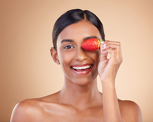 Image showing Portrait, beauty and strawberry with a model woman in studio on a beige background to promote skincare. Face, eye and fruit with an attractive young female posing for organic or natural cosmetics