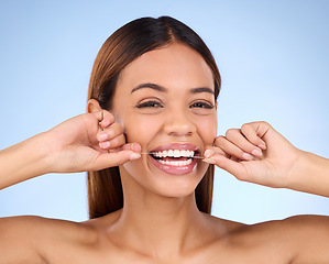 Image showing Dental floss, portrait and woman smile with teeth hygiene, healthcare and wellness treatment. Isolated, blue background and studio with a female feeling beauty from a clean mouth with self care