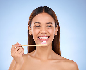 Image showing Toothbrush, portrait and dental with a woman in studio on a blue background for oral hygiene. Mouth, dentist and cleaning with an attractive young female brushing her teeth for healthy gums