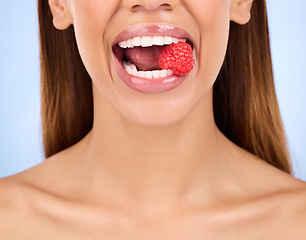 Image showing Woman, mouth and raspberry for skincare nutrition, dermatology or diet health plan against a studio background. Female lips with fruit for natural organic food, self care or eat for healthy wellness