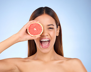 Image showing Beauty, excited woman and grapefruit portrait for skincare cosmetic and vitamin c. Female model on blue background for self care, facial glow or healthy fruit on natural skin and happy face in studio