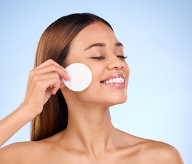 Image showing Skincare, woman and cotton pad on face for beauty with dermatology cosmetics in studio. Female model on a blue background for self care, facial glow and healthy or natural skin with detox results