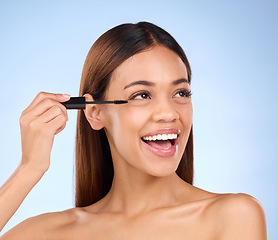 Image showing Beauty, mascara makeup and woman with cosmetics on face in studio. Excited female model person on a blue background for self care, facial glow and eyelash extension or growth with luxury product