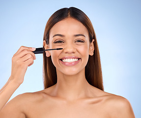 Image showing Beauty portrait, woman and mascara makeup with a smile for cosmetics on face in studio. Female model on blue background for self care, facial glow and eyelash extension or growth with luxury product