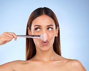 Image showing Beauty, makeup and brush on nose of woman in studio for cosmetics, tools and self care. Glow, foundation and blush with girl model on blue background for facial, powder and cosmetology product