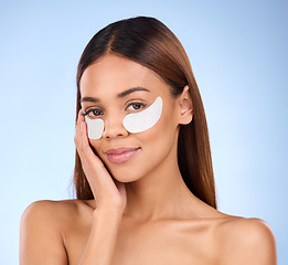 Image showing Skincare, collagen pads and portrait of woman with eye mask for anti aging skin glow on blue background. Cosmetics, facial repair and face of beauty model with wrinkle treatment product in studio.