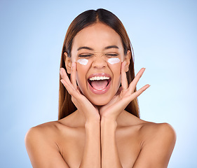 Image showing Dermatology, portrait of excited woman with cream on face and anti aging skin care on blue background. Cosmetics, facial and happy hispanic model, moisturizer solution or collagen product in studio.