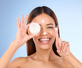 Image showing Woman, portrait and face with moisturizer cream for beauty skincare cosmetics, self love or care against a blue studio background. Happy female with lotion or moisturizing creme for facial treatment