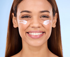 Image showing Skincare, eye cream and fresh face of happy woman with anti aging skin care beauty treatment on blue background. Cosmetics, facial and portrait of hispanic model with collagen product in studio promo