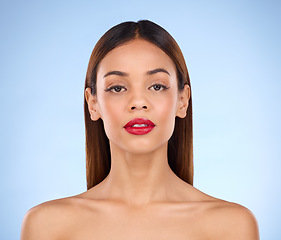 Image showing Makeup, woman and red lipstick beauty portrait with cosmetics on face in studio. Aesthetic female model person on a blue background for self care, facial glow and shine or color for skin and wellness