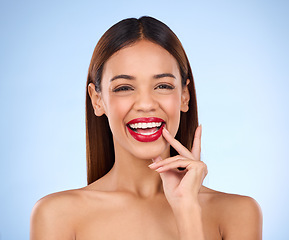 Image showing Beauty, happy woman and red lipstick makeup portrait with cosmetics on face in studio. Aesthetic female model person laughing on blue background for self care, facial glow and shine or color for skin