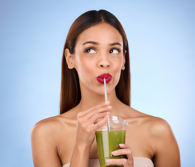 Image showing Beauty, smoothie and health with woman in studio for detox, nutrition and diet. Organic, drinking and minerals with girl model and green juice on blue background for vegan, fiber and protein