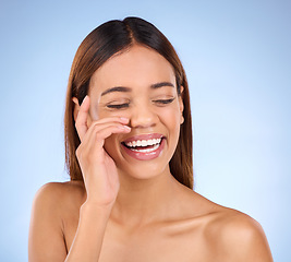 Image showing Skincare, beauty and happy woman with smile in studio for skin glow promo with hand on face on blue background. Makeup, facial and cosmetics, African model for dermatology or spa promotion and mockup