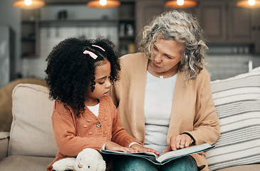 Image showing Family kid, book and grandmother reading fantasy storybook, story or bonding on home living room sofa. Love, grandma babysitting and senior woman with child development for adoption kindergarten girl