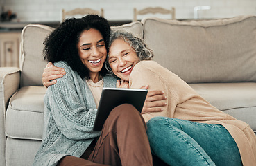 Image showing Tablet, daughter hug and happy senior mother with digital photo album, bonding and enjoy quality time together at home. Living room floor, memory and biracial family, people or mom and girl embrace