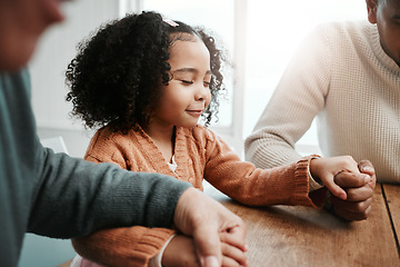 Image showing Worship, girl and family holding hands, praying and spiritual practice in home, peace and quality time. Female child, believers and group with support, holy and bonding with joy, guidance and praise