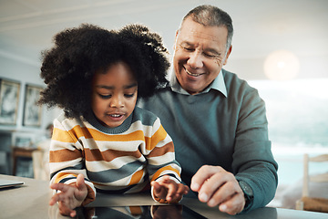 Image showing Education, home school and grandfather helping child with reading for an assignment or project. Learning, bonding and elderly man teaching boy kid grandchild with homework in the living room at home.
