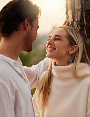 Image showing Happy, love and couple by tree in nature at sunset for romance, bonding and quality time together. Romantic, dating and man and girl show affection on holiday, honeymoon vacation and relax on weekend