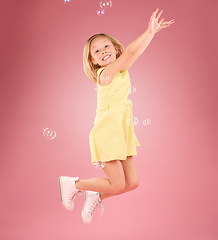 Image showing Child, jump and bubbles for a smile portrait in studio with a pink background for fun. Female kid model jumping with happiness, play and cheerful face isolated on gradient color and space