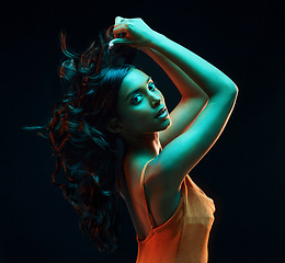 Image showing Trendy, fashion and portrait of a woman with style isolated on a black background in a studio. Looking, stylish and fashionable Indian model in fluorescent lighting for edgy look on a backdrop