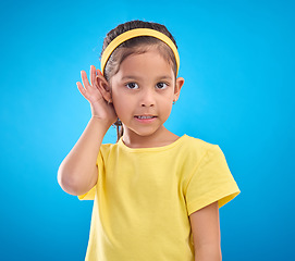 Image showing Hearing, eavesdrop and portrait of a children listening isolated on a blue background in a studio. Listen, attention and young girl holding an ear for sound, gossip and a secret on a backdrop