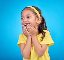 Image showing Laughing, happy and child looking curious while isolated on a blue background in a studio. Smile, cheerful and an adorable little girl with a laugh, happiness and innocent delight on a backdrop