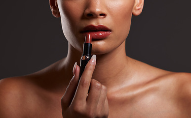 Image showing Makeup, lips and hands of woman with lipstick in studio for cosmetics and skincare products. Salon aesthetic, cosmetology and girl model with red gloss for beauty, mouth and luxury style