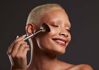 Image showing Woman, smile and makeup brush for beauty cosmetics, skincare or facial treatment against a gray studio background. Happy beautiful female model applying cosmetic product on face for self care or love