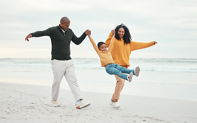 Image showing Play, mother and father with child on beach enjoy holiday, travel vacation and weekend together. Happy family, parents and dad, mom and kid holding hands for bonding, quality time and swinging by sea