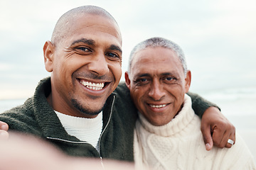 Image showing Smile, portrait and selfie by father with adult son hug at beach for travel, bond and having fun. Face, photo and man with mature parent on ocean trip in Miami, happy and pose for profile picture