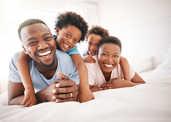 Image showing Happy, laughing and portrait of a black family on a bed for playing, quality time and comfort. Bonding, love and African children with parents in bedroom for happiness and relaxation in the morning