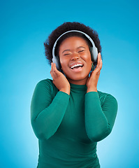 Image showing Happy, music and headphones with black woman in studio for streaming, singing and relax. Online radio, technology and listening with female isolated on blue background for hip hop and subscription