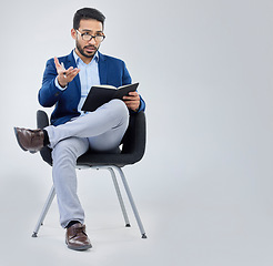 Image showing Human resources, questions and businessman with notebook for interview process in studio on grey background. Recruiter, asian male and recruitment process, negotiation and onboarding discussion