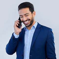 Image showing Smile, phone call and asian businessman in studio, talking and networking on white background. Smartphone, conversation and man in suit, communication and technology for investor trading at startup.