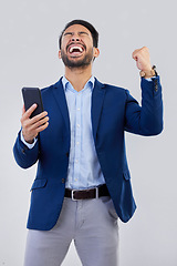 Image showing Winner, excited and phone with man in studio for good news, success and bonus. Pride, yes and celebration with male and cheering isolated on gray background for achievement, pride and job promotion