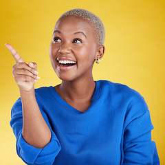 Image showing Smile, pointing to mockup and black woman in studio isolated on a yellow background. Thinking, happy and African female model point to advertising, marketing or product placement for branding space.