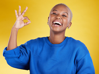 Image showing Portrait, laughing and black woman with ok sign in studio isolated on a yellow background. Success, emoji face and happy, comic and funny female with hand gesture for okay, support or perfection.