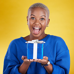 Image showing Excited, portrait and black woman with birthday gift in studio isolated on a yellow background. Face, box and happy African female with present for celebration, party and holiday for special event.