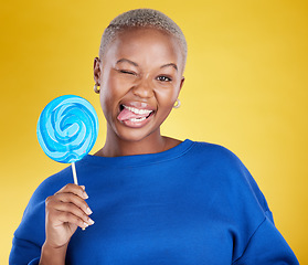 Image showing Portrait, funny and black woman with lollipop, candy and happiness against a studio background. Face, African American female and lady with sweets, dessert and treats with silly, goofy and cheerful